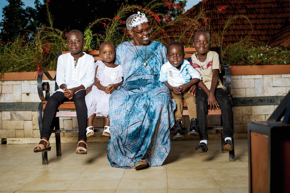 An older woman sitting on a bench with three children