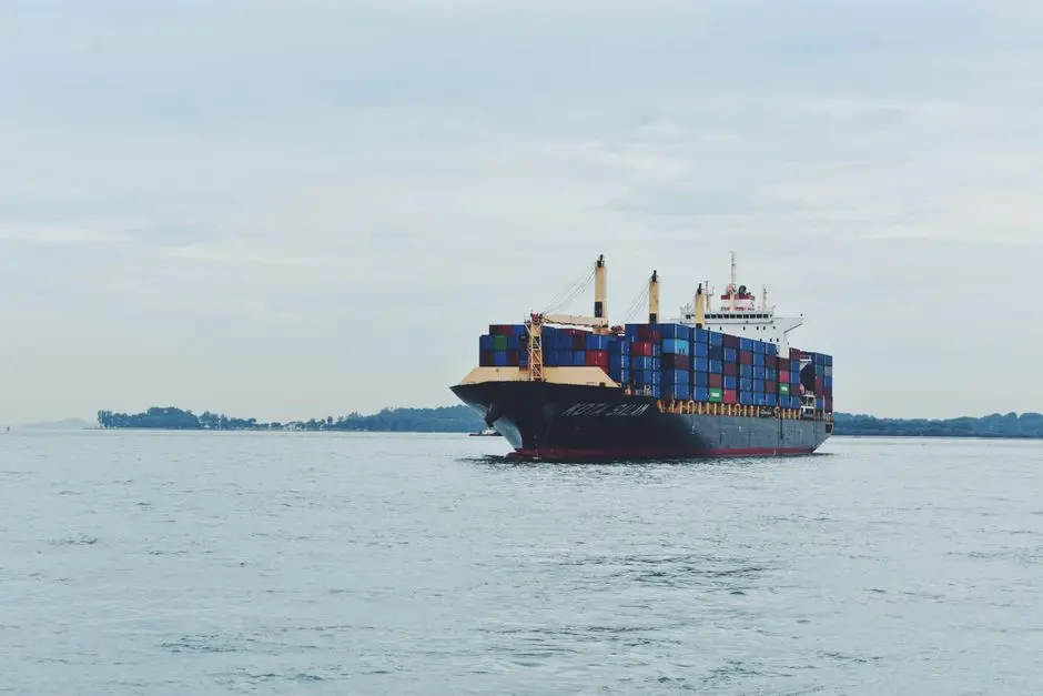 Large cargo ship transporting containers across a calm sea, symbolizing global logistics.