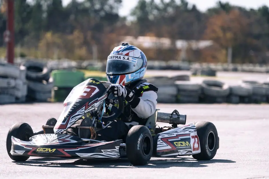 A go-kart racer in action on a sunny day at the race track, showcasing speed and skill.