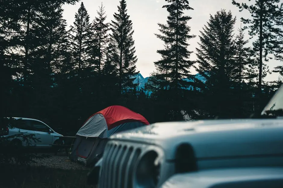 Camping scene in Jasper National Park with tents and vehicles in a forest setting.