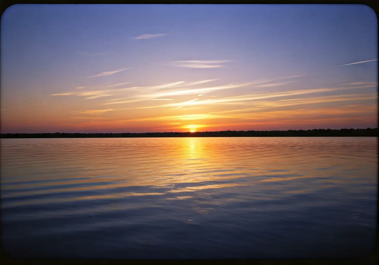 A serene sunset view over a calm, reflective lake. 35mm stock photo