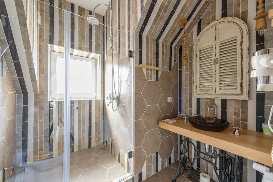 Beautifully designed bathroom featuring stylish tiles, glass shower, and unique sink area.