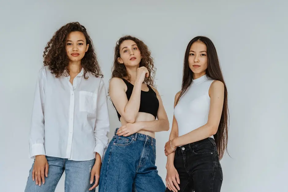 Trio of diverse women posing in casual denim and stylish tops for a contemporary photoshoot.