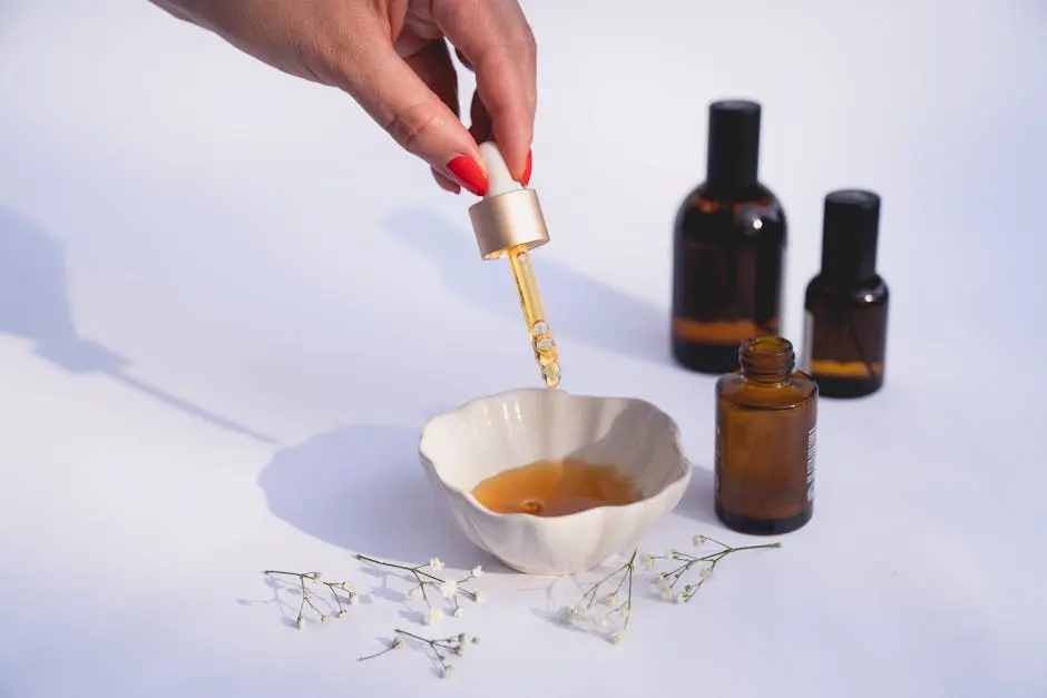 Stylish composition of a skincare routine with dropper bottles and dried flowers on a white background.