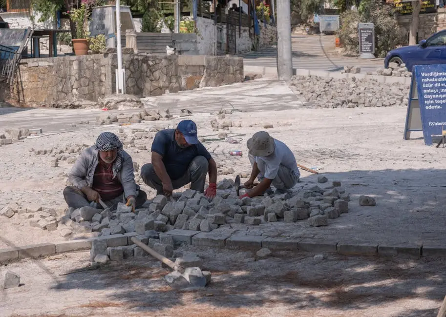Hardworking individuals laying cobblestones on a sunny street in İzmir, Türkiye