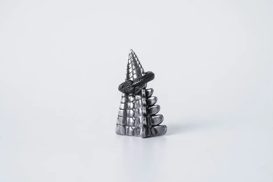 A detailed silver snake ring displayed on a textured pyramid stand, symbolizing eternity.