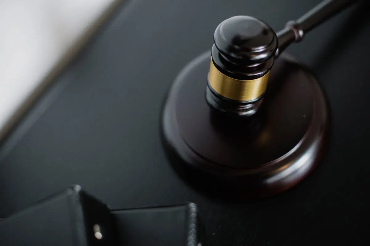 Close-up of a wooden judge’s gavel on a black desk, symbolizing justice and law.