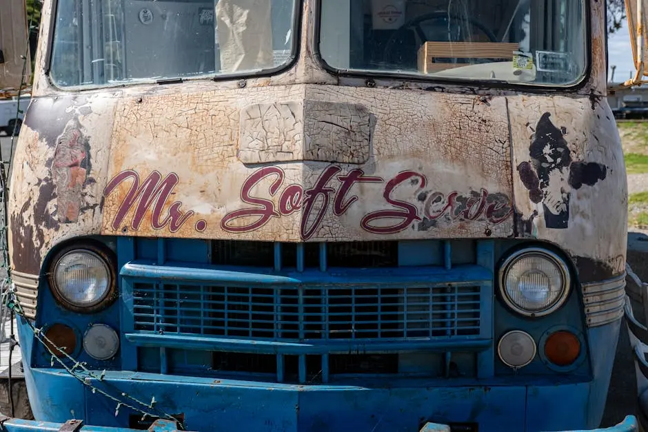 A close-up of a weathered vintage ice cream truck featuring the text ‘Mr. Soft Serve’.