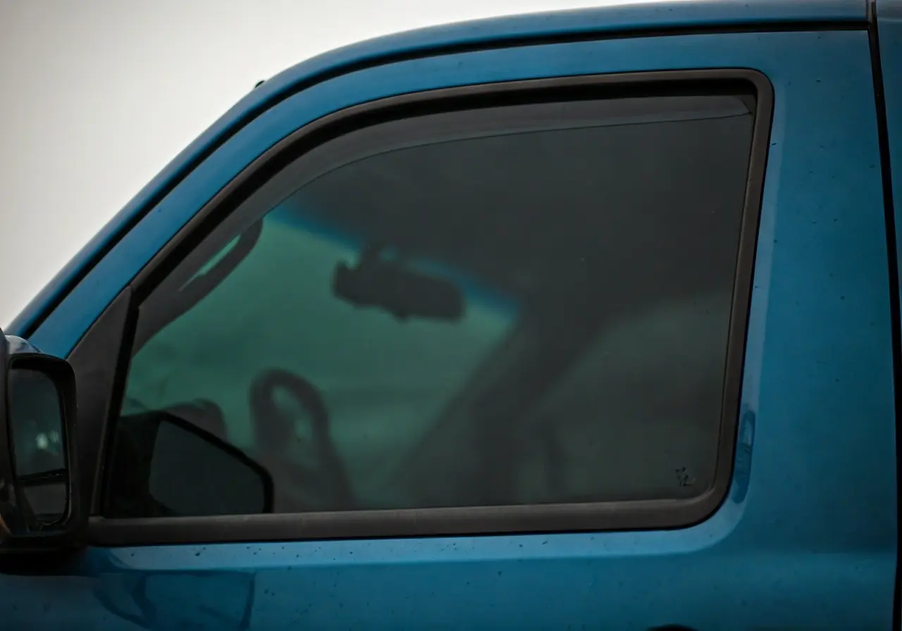 A close-up of a truck window with dark tint. 35mm stock photo