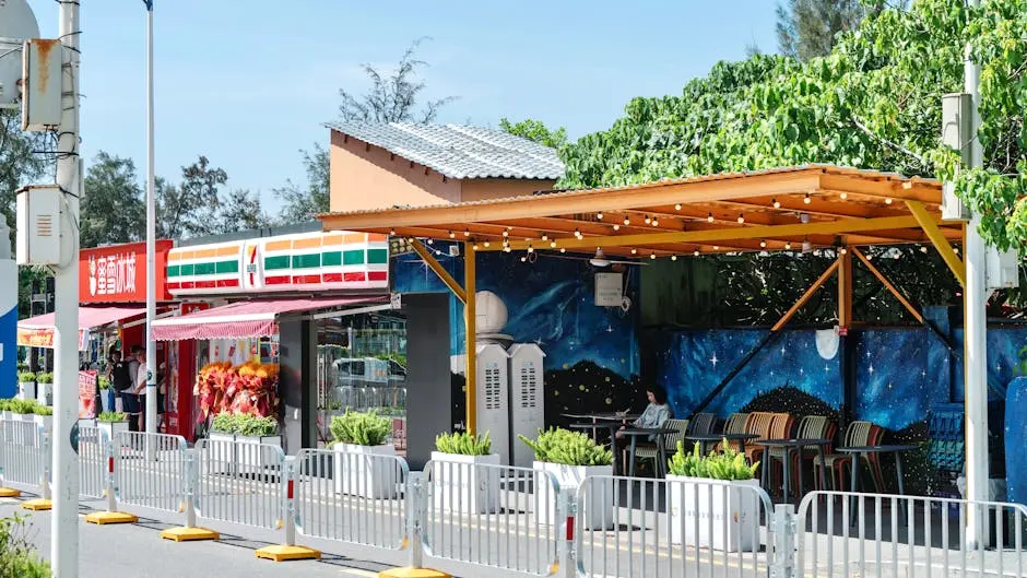 Bright outdoor café with a vibrant mural next to popular shops.