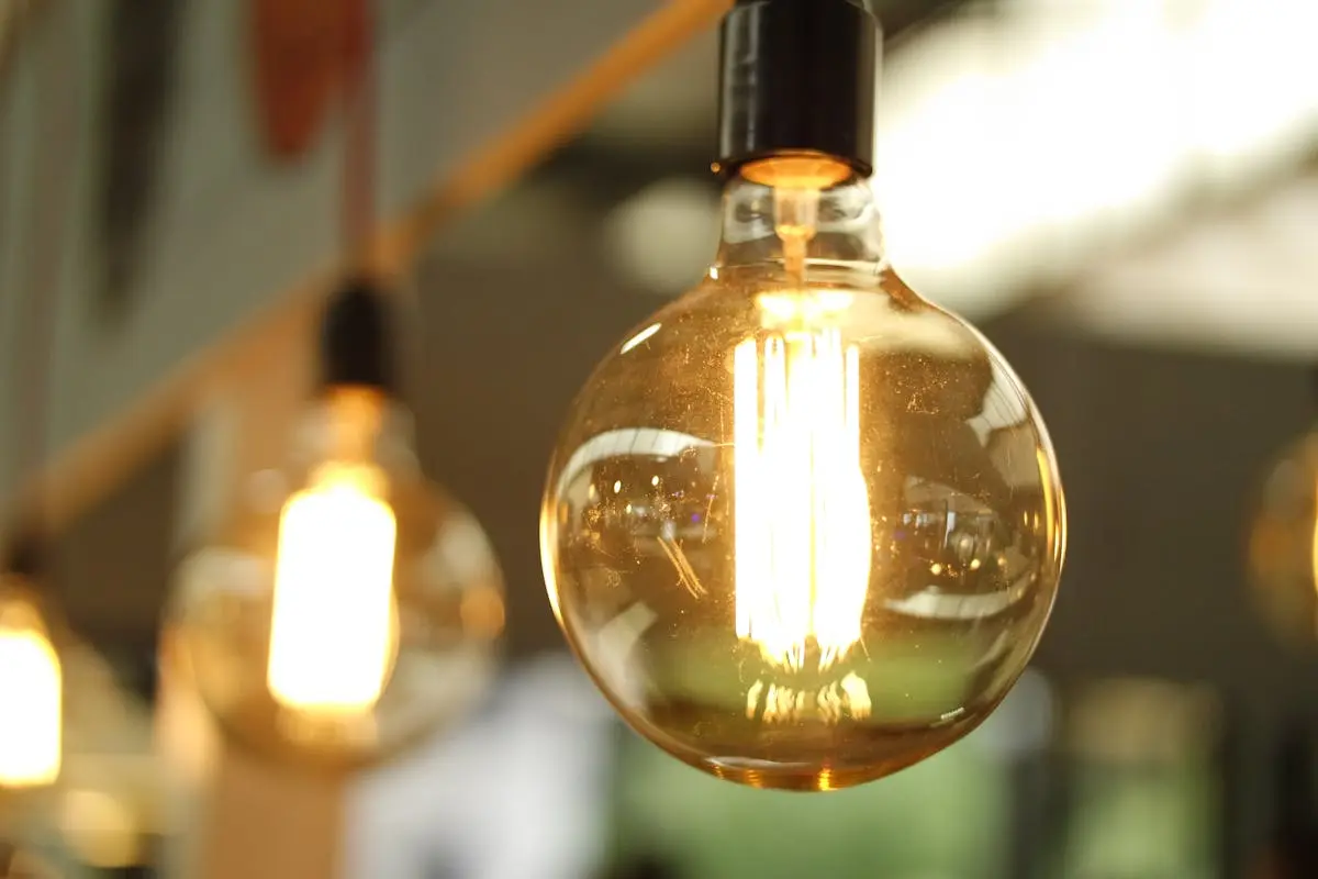 A close-up of a glowing vintage Edison bulb creating a warm atmosphere. fractional coo