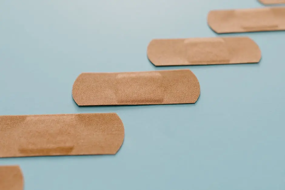 A series of adhesive bandages arranged on a soft blue background, highlighting their sterile simplicity.