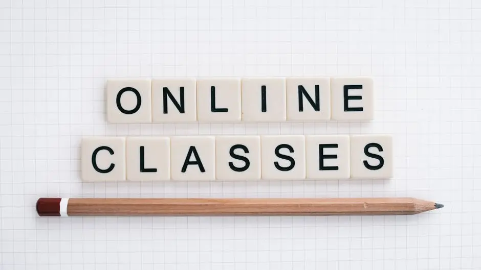 Flat lay of Scrabble tiles spelling ‘Online Classes’ with pencil on grid paper background.