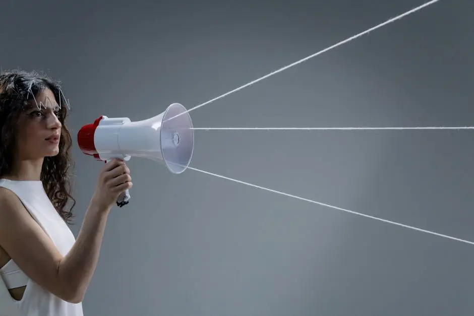 Young woman in a white tank top using a megaphone in a conceptual studio shoot.