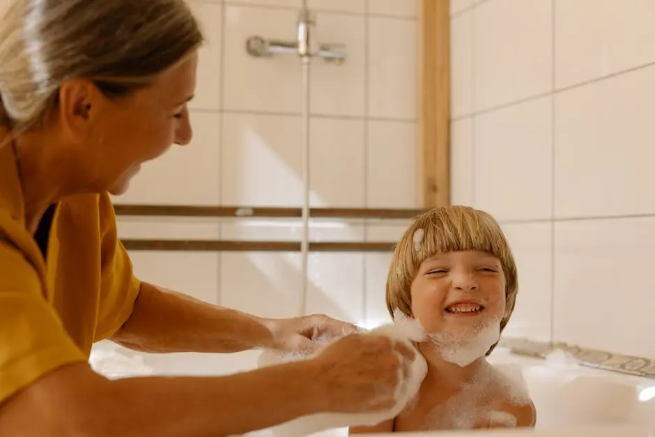 A joyful moment of a grandmother washing her playful grandson in a sunlit bathroom.