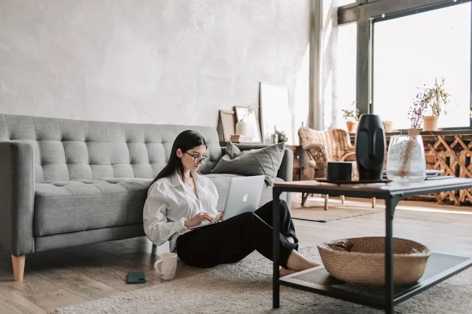 A woman working remotely with a laptop in a stylish, well-lit apartment, embodying a modern lifestyle.