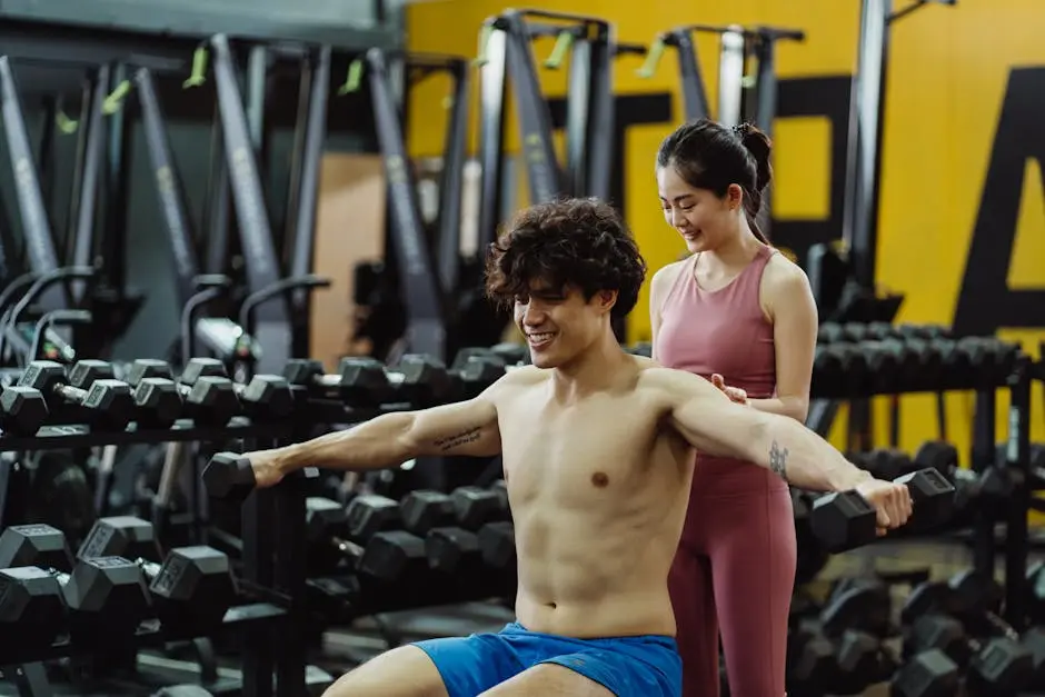 Two young adults exercising in a gym, with diverse sports equipment around them.