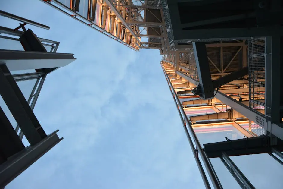 Low angle shot of modern steel structure reaching into the sky, daytime.