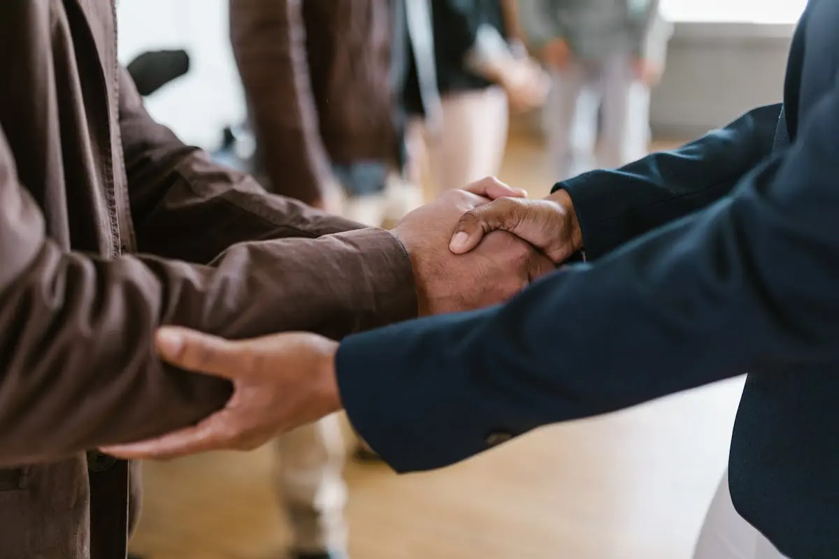 Close-up of two businesspeople shaking hands, symbolizing agreement and partnership. How to Buy a Small Business