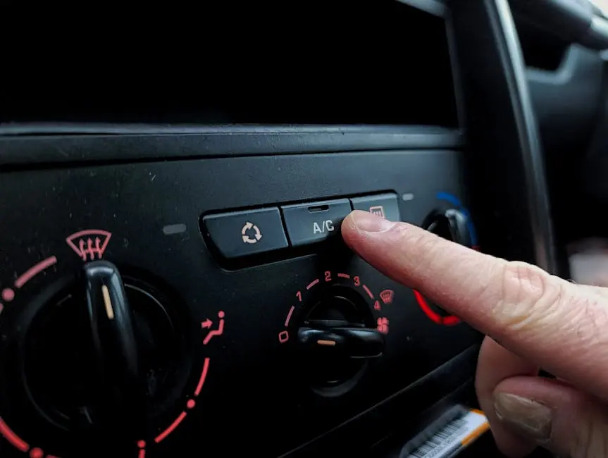 Close-up of a person adjusting a car’s air conditioning system inside a vehicle cabin.
