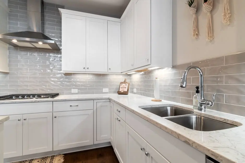 Sleek white kitchen with marble countertops and modern fixtures.