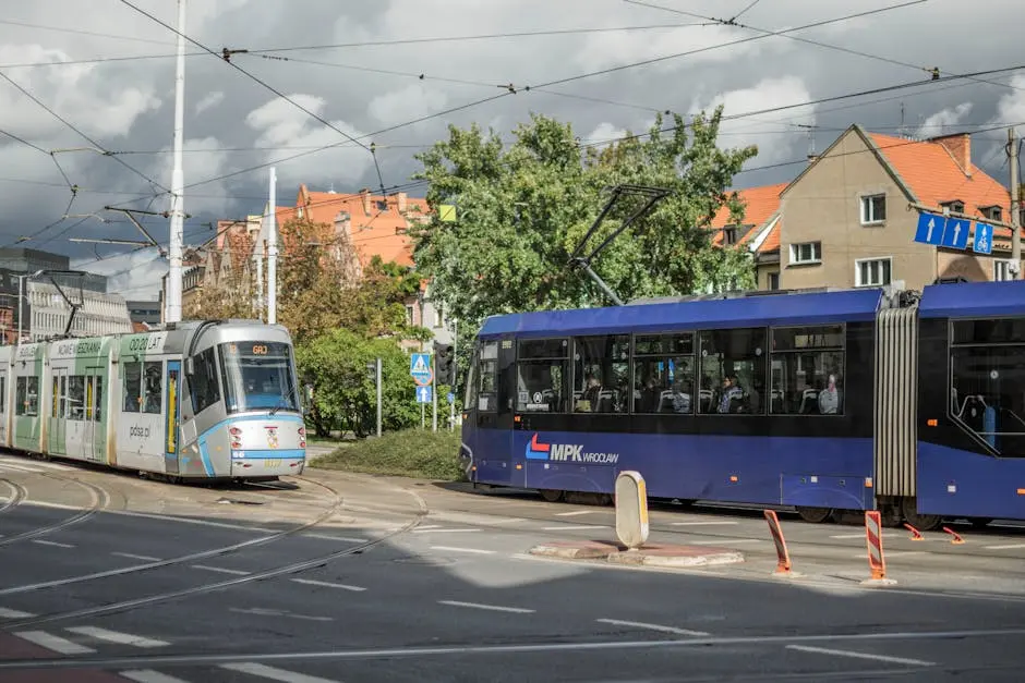 Two trams pass on a sunny day in Wrocław, Poland, showcasing city transportation.