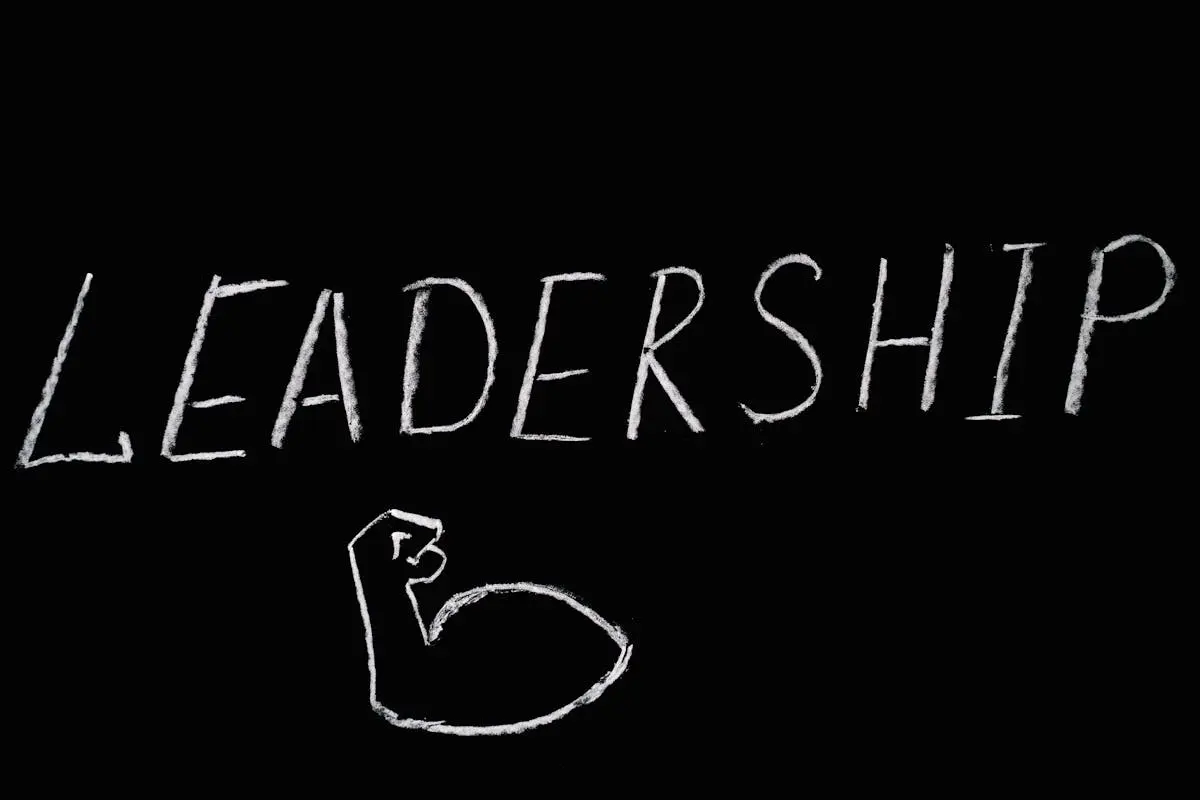 Chalkboard art showcasing the word ‘Leadership’ and a drawn muscle symbolizing strength.