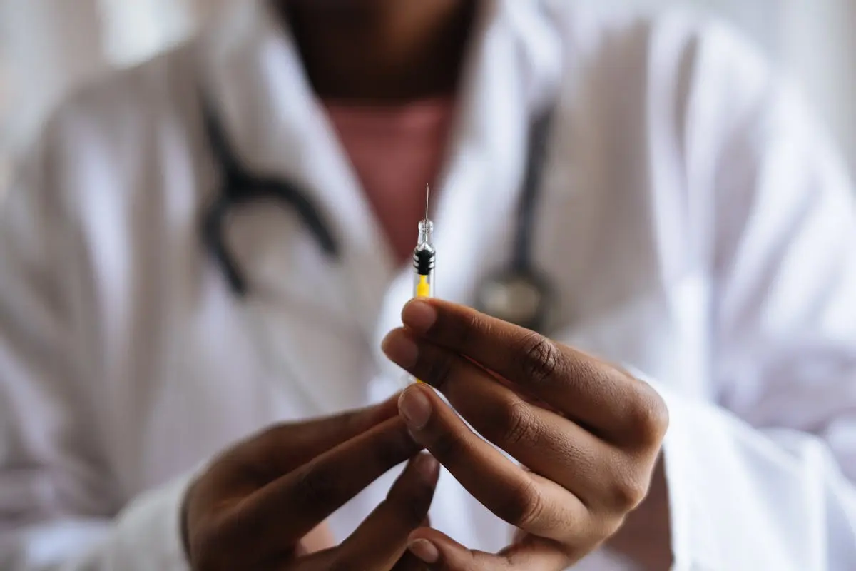 Close-up of a healthcare professional holding a syringe, symbolizing medical care and vaccination.
