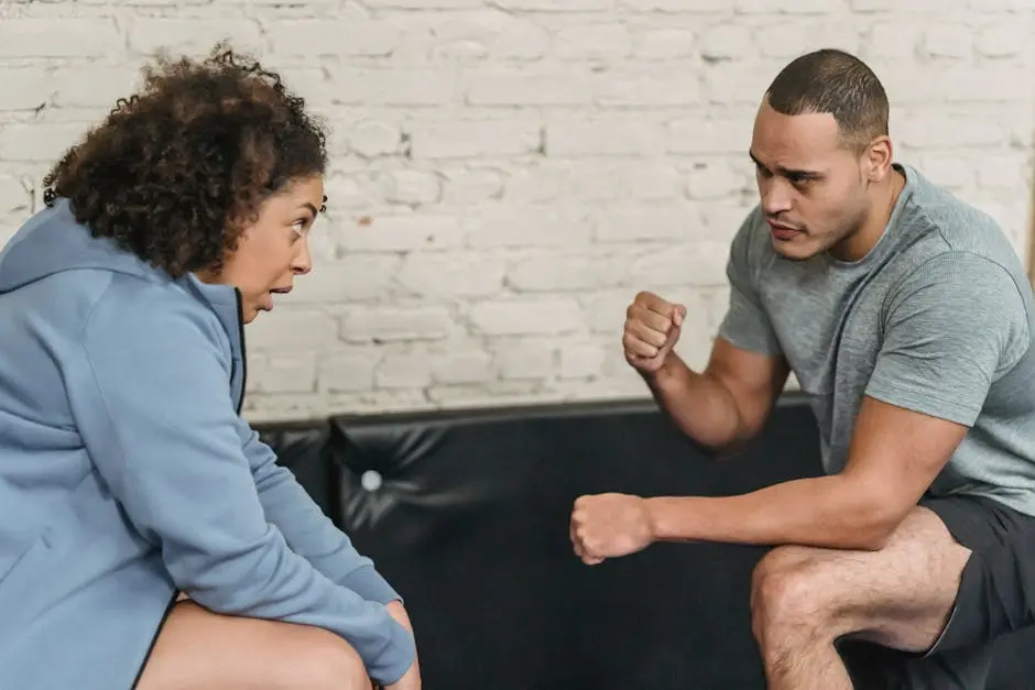 A focused fitness coach encouraging a woman during an indoor workout session.