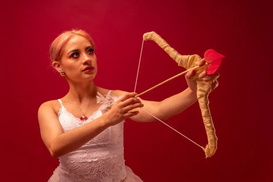 Artistic portrayal of a ballet dancer dressed as Cupid aiming a bow and arrow against a red background.
