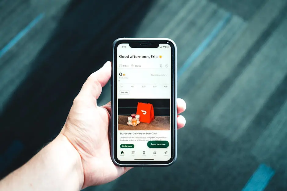 Close-up of a smartphone with a delivery app interface in a person’s hand, emphasizing modern e-commerce.