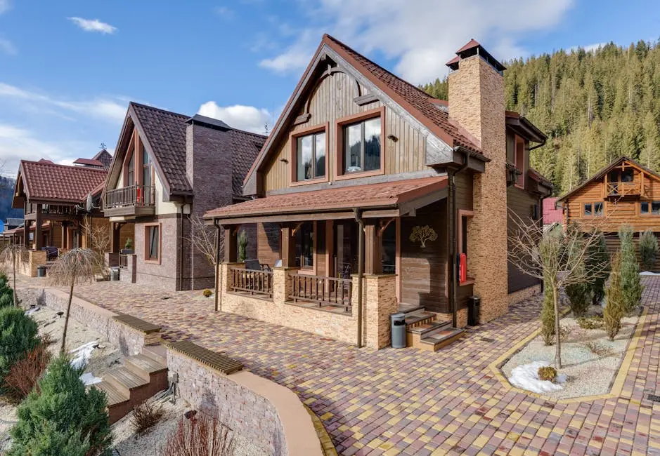 Picturesque wooden chalets nestled in a mountainous landscape under clear blue skies.