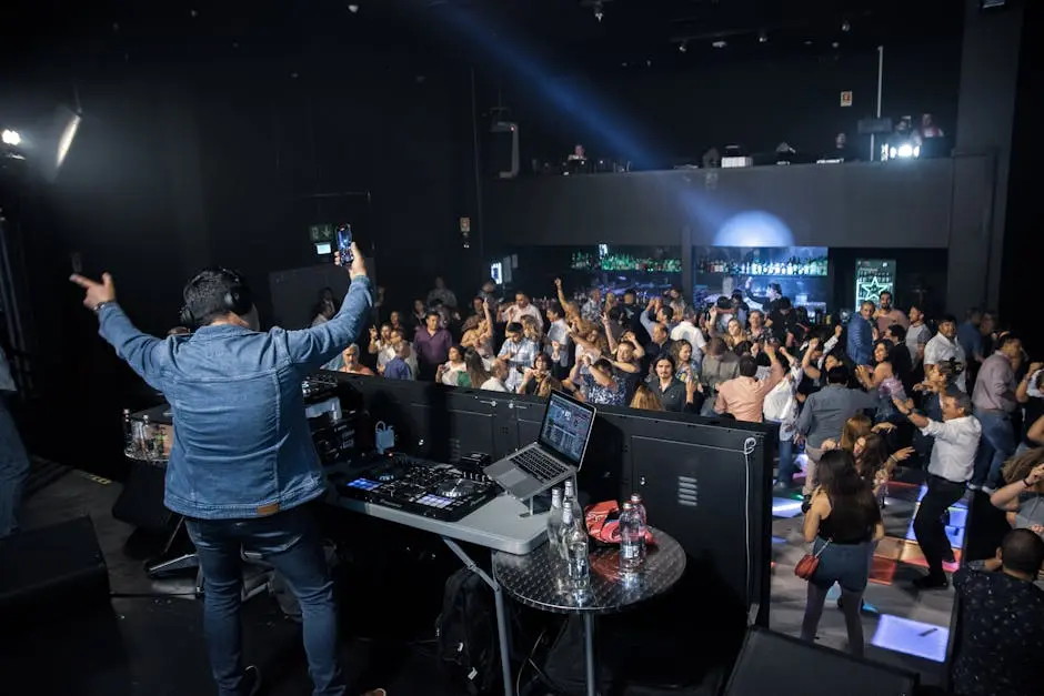 DJ engaging a lively crowd at an indoor nightclub, creating vibrant party vibes.