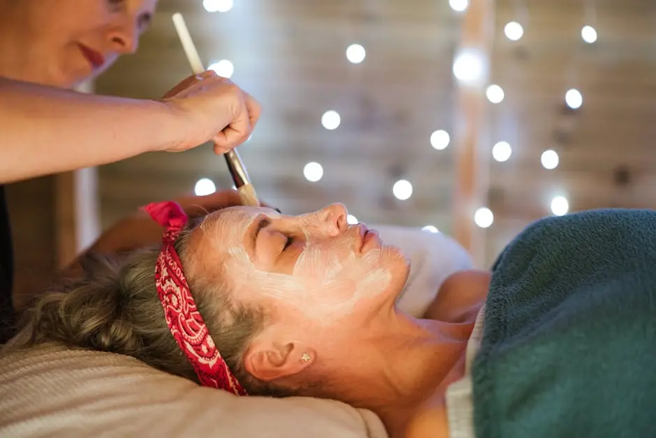 Woman receiving a calming facial treatment in a serene spa setting with gentle lighting.