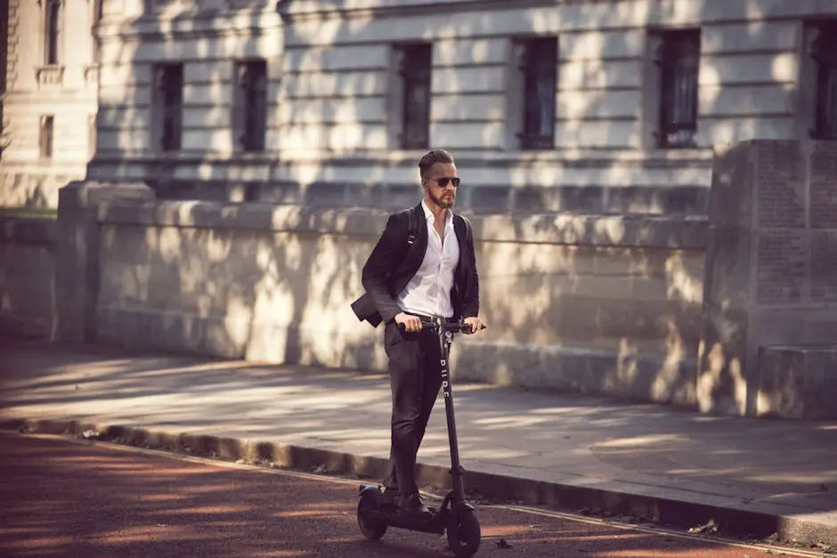 Man in a suit riding an electric scooter on a city street, showcasing modern urban transportation.
