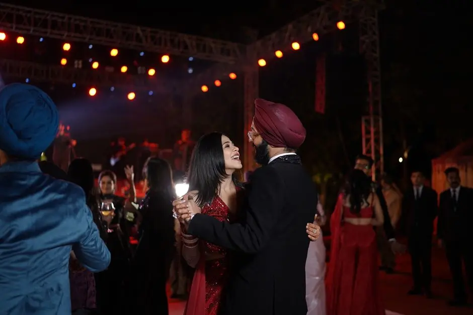 Couple dancing under vibrant lights at a lively wedding reception.