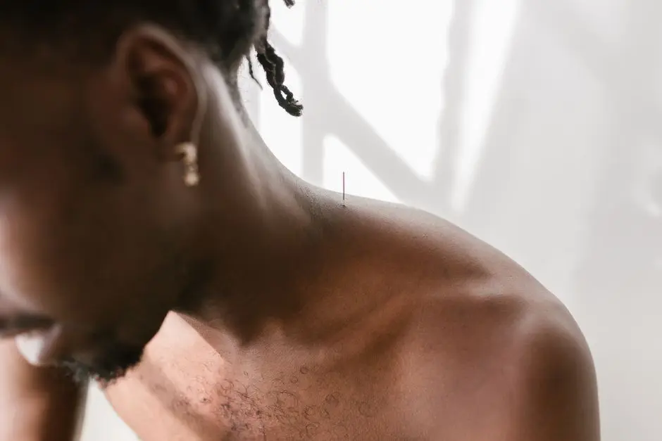 A man receiving acupuncture therapy on his shoulder for pain relief and wellness.