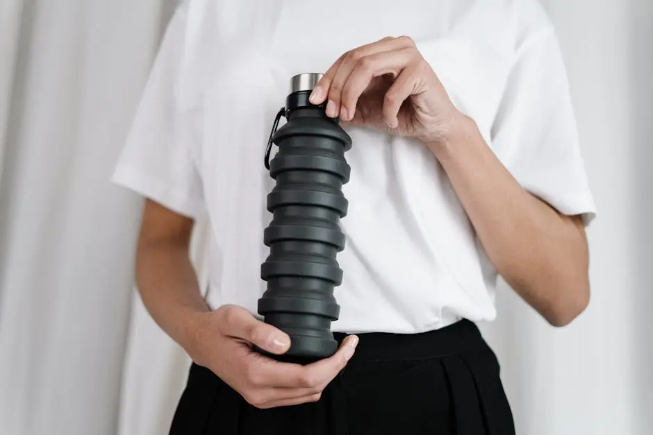 Minimalistic image showing a black collapsible tumbler being held, symbolizing eco-friendly practices and zero waste lifestyle.