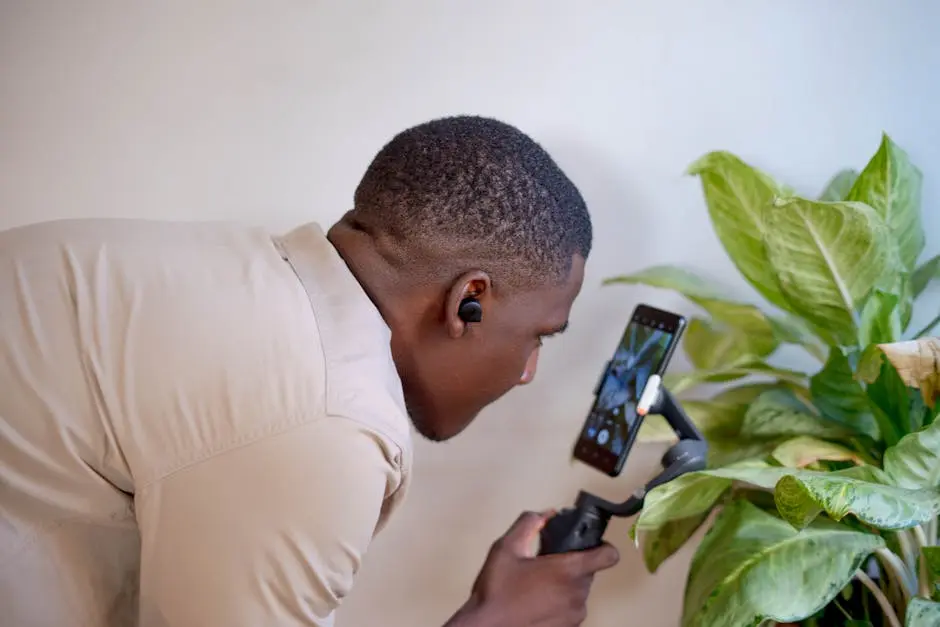 A man uses a phone gimbal for vlogging indoors, showcasing technology and creativity.