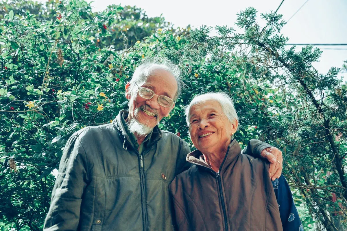 Senior couple enjoying a joyful moment together in a lush garden setting, exuding love and happiness.