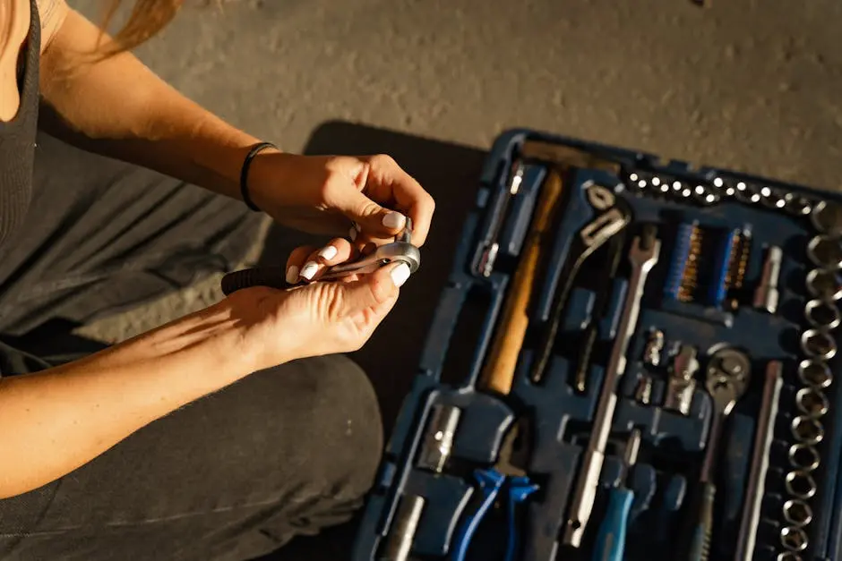 Close-up of hands using tools from a toolset in a well-lit workshop setting.