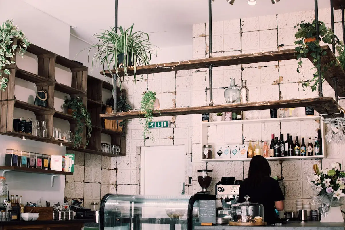 Charming rustic café interior with lush plants and a barista at work, featuring a vintage vibe.