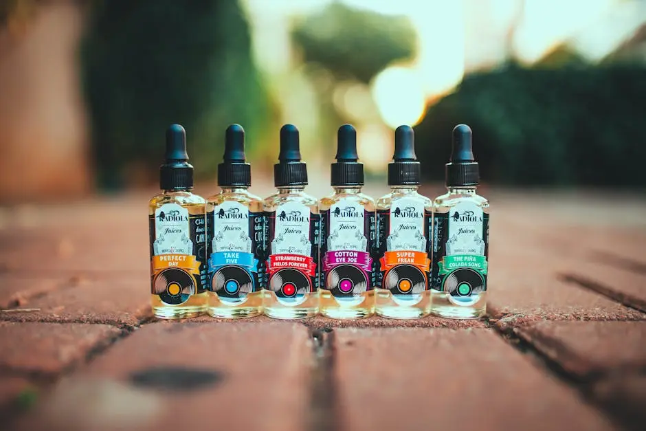 Vibrant vape juice bottles arranged on a brick pathway outdoors in a row.