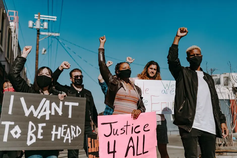 A diverse group of people protesting for justice and equality with banners.