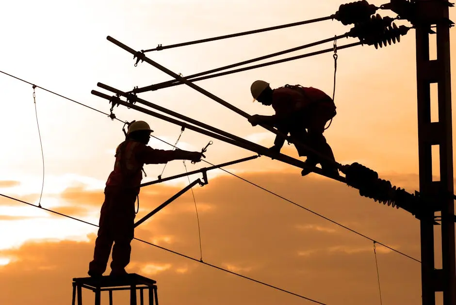 Electricians repairing power lines at sunset, showcasing teamwork and safety.