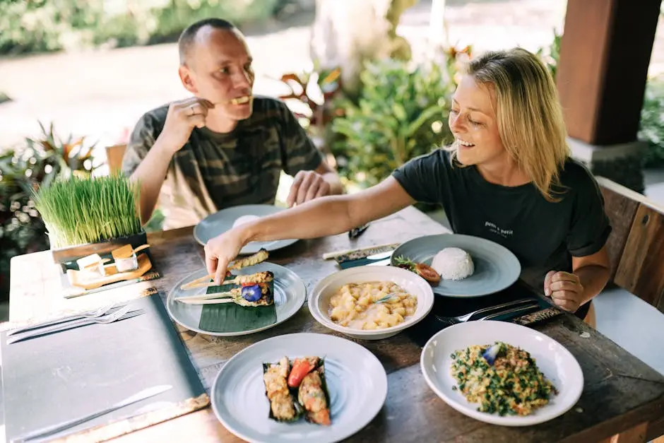 A couple enjoying a variety of Asian dishes outdoors at a cozy table setting.