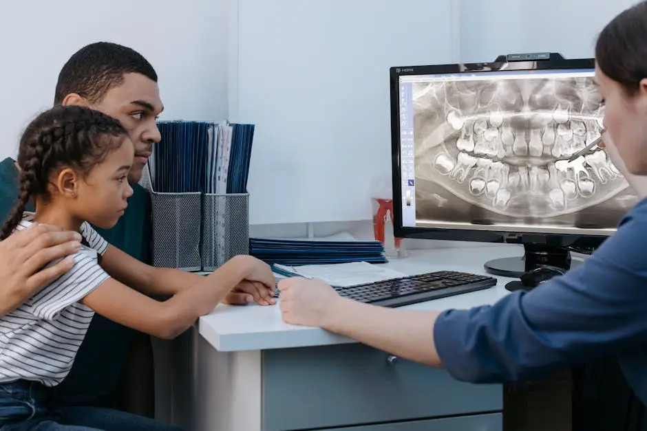 A father and daughter discuss dental care with a dentist reviewing an X-ray.
