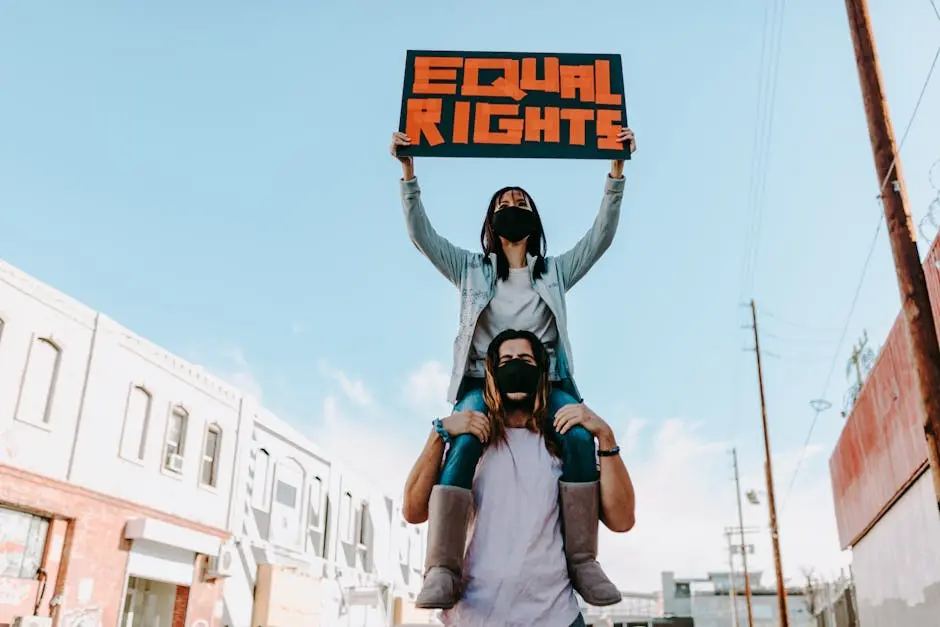 Two people at a protest holding an ‘Equal Rights’ sign, advocating for social justice.