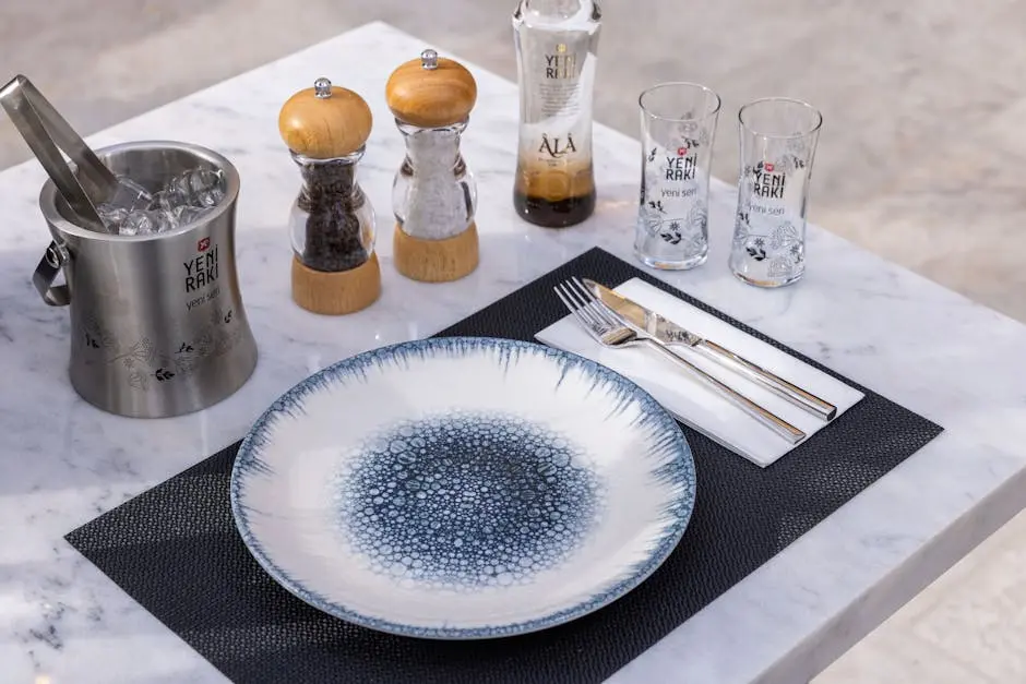 Elegant tabletop setup featuring Yeni Rakı, ice bucket, spice shakers, and a stylish dish.