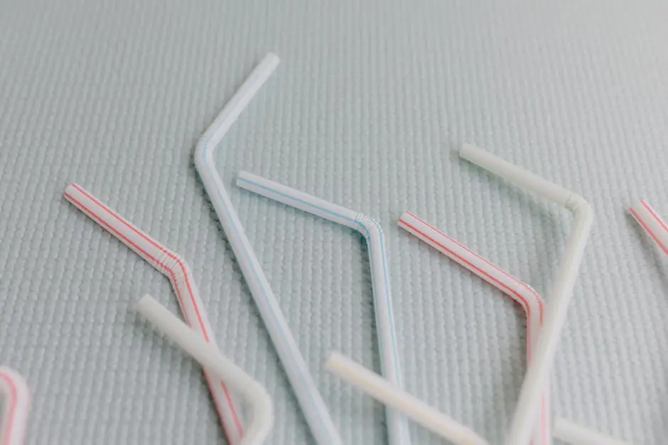 Close-up of colorful plastic straws on a textured light background highlighting environmental issues.